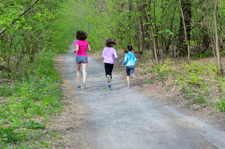 Family fitness and sport, happy active mother and kids jogging outdoors, running in forestの写真素材