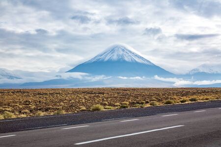 Road in Atacama desert savanna, mountains and volcano landscape, Chile, South America