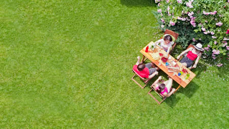 Family and friends eating together outdoors on summer garden party. Aerial view of table with food and drinks from above. Leisure, holidays and picnic conceptの写真素材