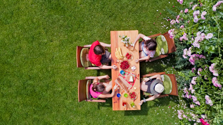 Family and friends eating together outdoors on summer garden party. Aerial view of table with food and drinks from above. Leisure, holidays and picnic conceptの写真素材