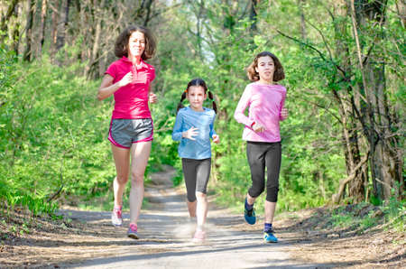 Family running, happy active mother and kids jogging outdoors, run with children in forest, healthy family sport and fitnessの写真素材