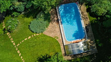 Swimming pool in beautiful garden aerial top view