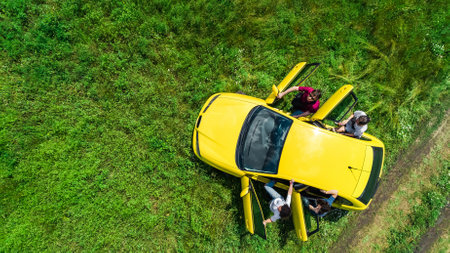 Family and friends car travel on vacation, happy parents and kids have fun in holiday trip, aerial drone view of car and people from aboveの写真素材