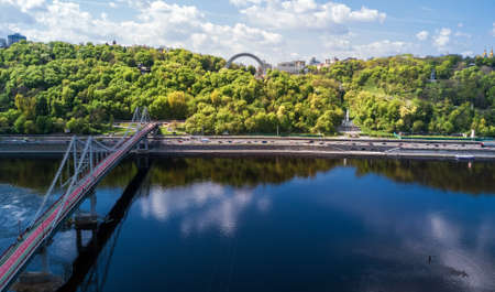 Kyiv city skyline and Dnipro river aerial drone view from above, Kiev hills, pedestrian Park bridge and Dnieper river cityscape in spring, Ukraineの写真素材