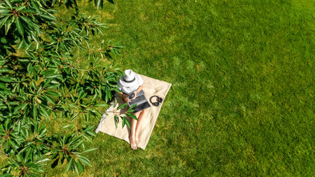 Young woman using laptop computer in park, student girl freelancer working and studying online...