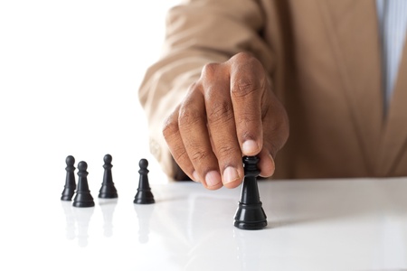 Business man moving chess figure with team behind - strategy or leadership conceptの写真素材