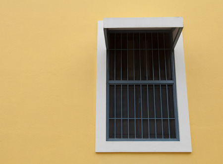 closed White and blue window on yellow wallの写真素材