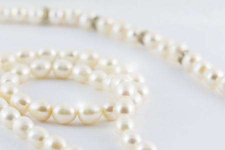 Beautiful creamy pearls necklace curve isolated on white background.の写真素材