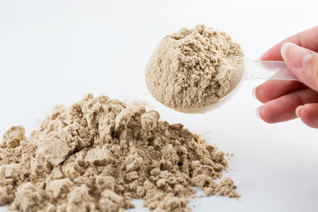 The hand raise a spoon measure Whey protein chocolate powder for fitness and bodybuilding gaining...