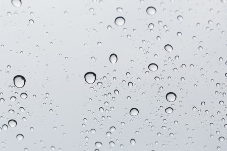 Water drop on glass mirror background.の写真素材