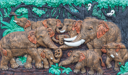 Nakhonnayok, THAILAND - May 3, 2015 : Antique decorate wall : Elephants playing in the forest.のeditorial素材
