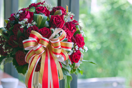 Red rose flower in vase side mirror on tree background.の写真素材
