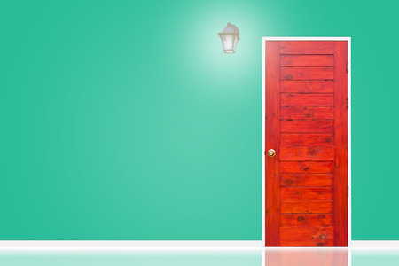 Wooden door and lamp with isolated green vintage wall texture.の写真素材