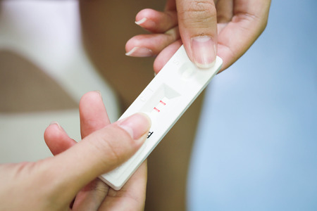 Young woman checking pregnancy test.の写真素材