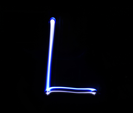 L Lima alphabet hand writing blue light  over black background.の写真素材