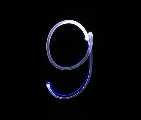 Nine blue light digit hand writing over black background.の写真素材