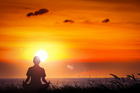 Silhouette of young women yoga at the sunset on hill.の写真素材