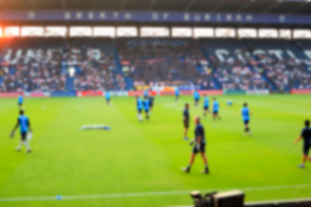 Blurry de-focused stadium and player football background.の写真素材