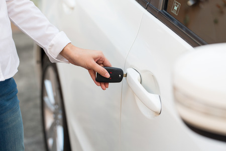 Female hand open the white car on key system automatic.の写真素材