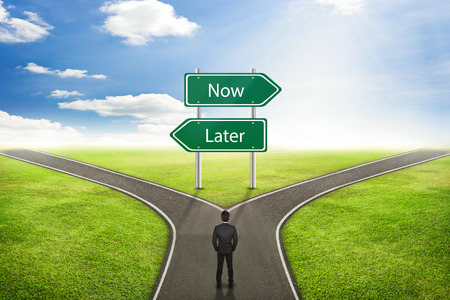 Businessman concept, Sign Now or Later road to the correct way.の写真素材