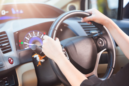 Women holding wheel and driving a car in a good time, selective focusの写真素材