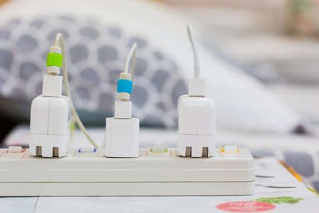 Electrical appliances plugged, several adapter and charger.の写真素材