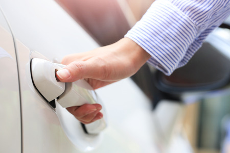 Business hand on handle. Close-up female opening a car door.の写真素材