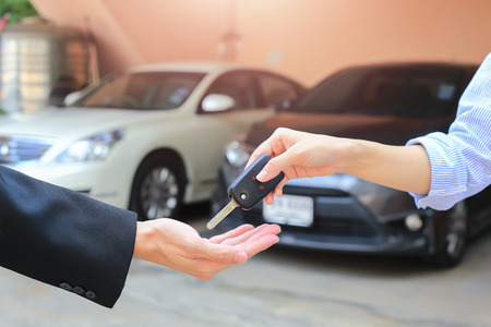 Female hand giving a key for buyer or rental car.の写真素材