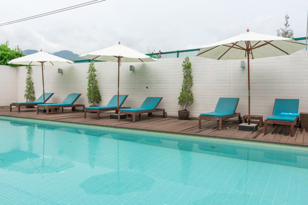 Beach chairs and swimming pool in the resort holiday.の写真素材