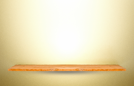 Wooden shelf on gold cement wall background.の写真素材