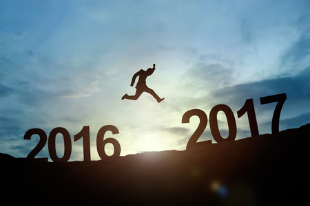 Silhouette of businessman glowing jump 2016 to 2017. success conceptの写真素材