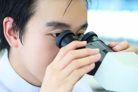 Scientist using a microscope at work in a laboratory.