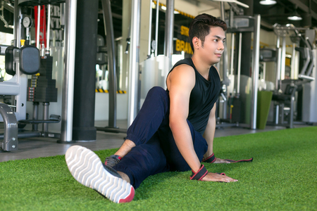 Portrait of a man doing stretching exercises at gym.の写真素材