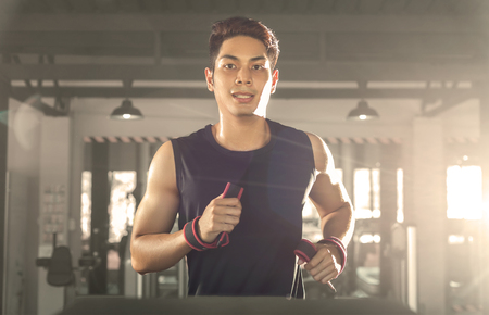 Smart man running on treadmill in gym.の写真素材