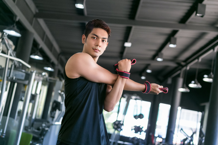 Portrait of a man doing stretching exercises at gym.の写真素材