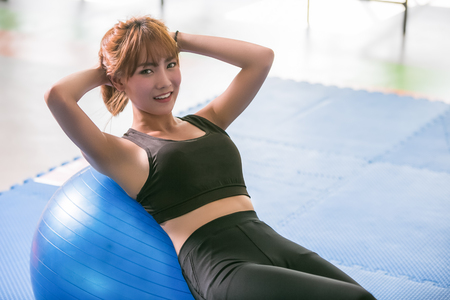 Sporty girl happy doing situps in gym.の写真素材