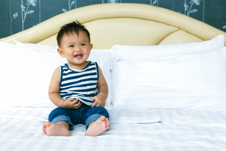 Morning awakening little child boy happiness in bed.の写真素材