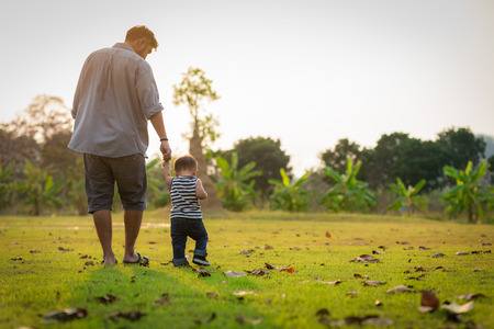 Happy father and little boy walking in summer park. adoption and people concept.の写真素材