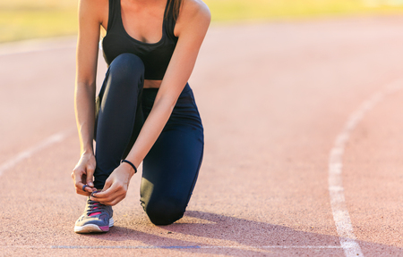 Female runner tying lace on stadium.の写真素材