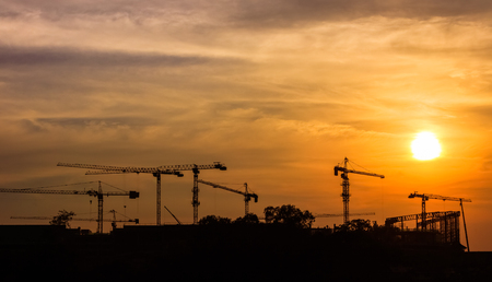 Industrial landscape with silhouettes of cranes on the sunset.の写真素材