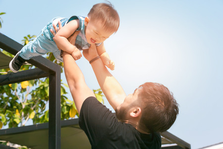 Happy joyful father having fun throws up in the air child. father's day. selective focusの写真素材