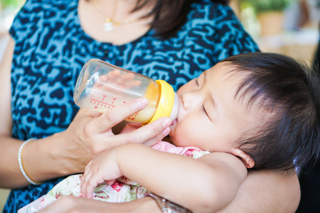 Closeup of baby feeding milk from baby's bottle. Family conceptsの写真素材