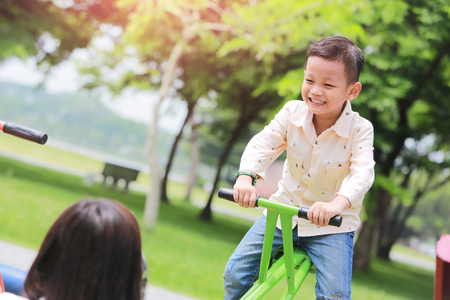 Mother with son playing seesaw in the park.の写真素材