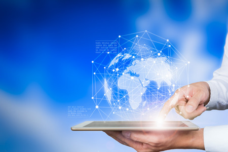 Business holding tablet touching screen world map.の写真素材