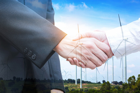 Double exposure of handshake with wind turbine. Ecology conceptの写真素材