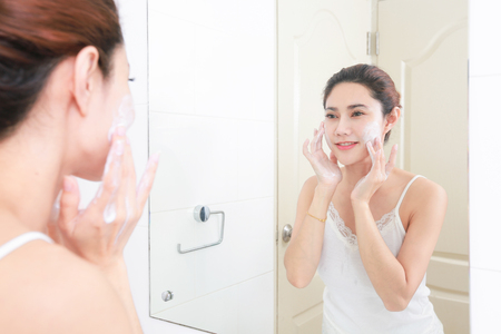 Asian woman cleaning face skin enjoy herself with bubble cleansing foam.の写真素材