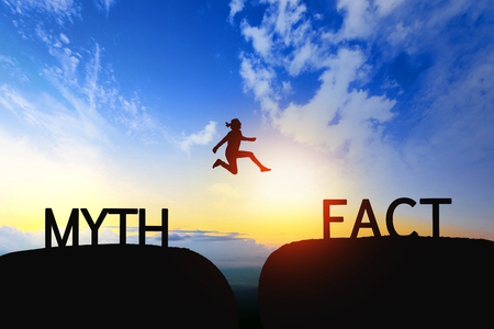 Woman jump through the gap between Myth to Fact on sunset.の写真素材