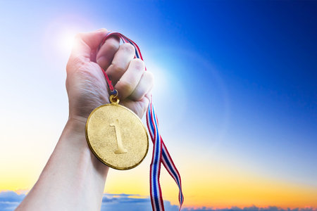 Businessman hand holding golden coin medal.の写真素材