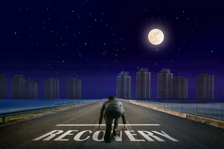 Businessman RECOVERY line in front of city. Night back view. Elements of this image furnished by NASA.の写真素材