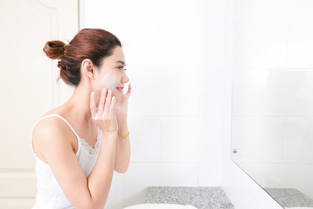 Asian woman cleaning face skin enjoy herself with bubble cleansing foam.の写真素材